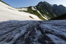 朝焼け撮影後に朝食を頂いた後は、雪の剱沢を駆け下ります。
何本も雪渓を下りたり横断しながら剱山荘と剱岳に近づいていきます。
広大な雪渓越しに見る剱岳がいかつく聳えている。