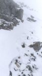 さらに高度を上げて西側の岩場を回り込むと、壁だよ!雪の大壁だよ!
視界もほとんど効かない状態で難所のトラバースが現れた。
うゎ~、マジっすか。落ちたら死にますよコレ!恐ろしぃ~。
幸いなことに先行者の明瞭なステップが切ってあるので、それに頼るしかない。